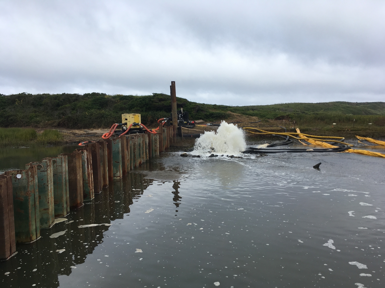 Initial dewatering of the work area behind sheet pile dam, July 2019