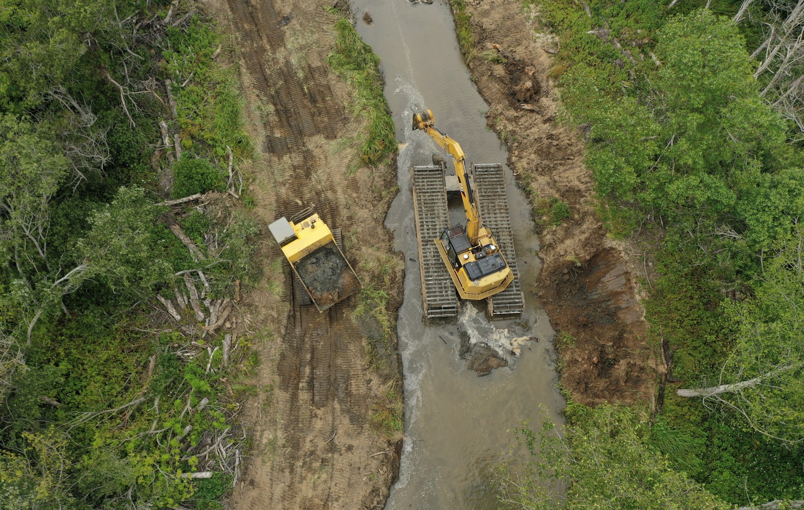 Dredging sediment Heavy machinery in the middle of a waterway, digging up sediment.