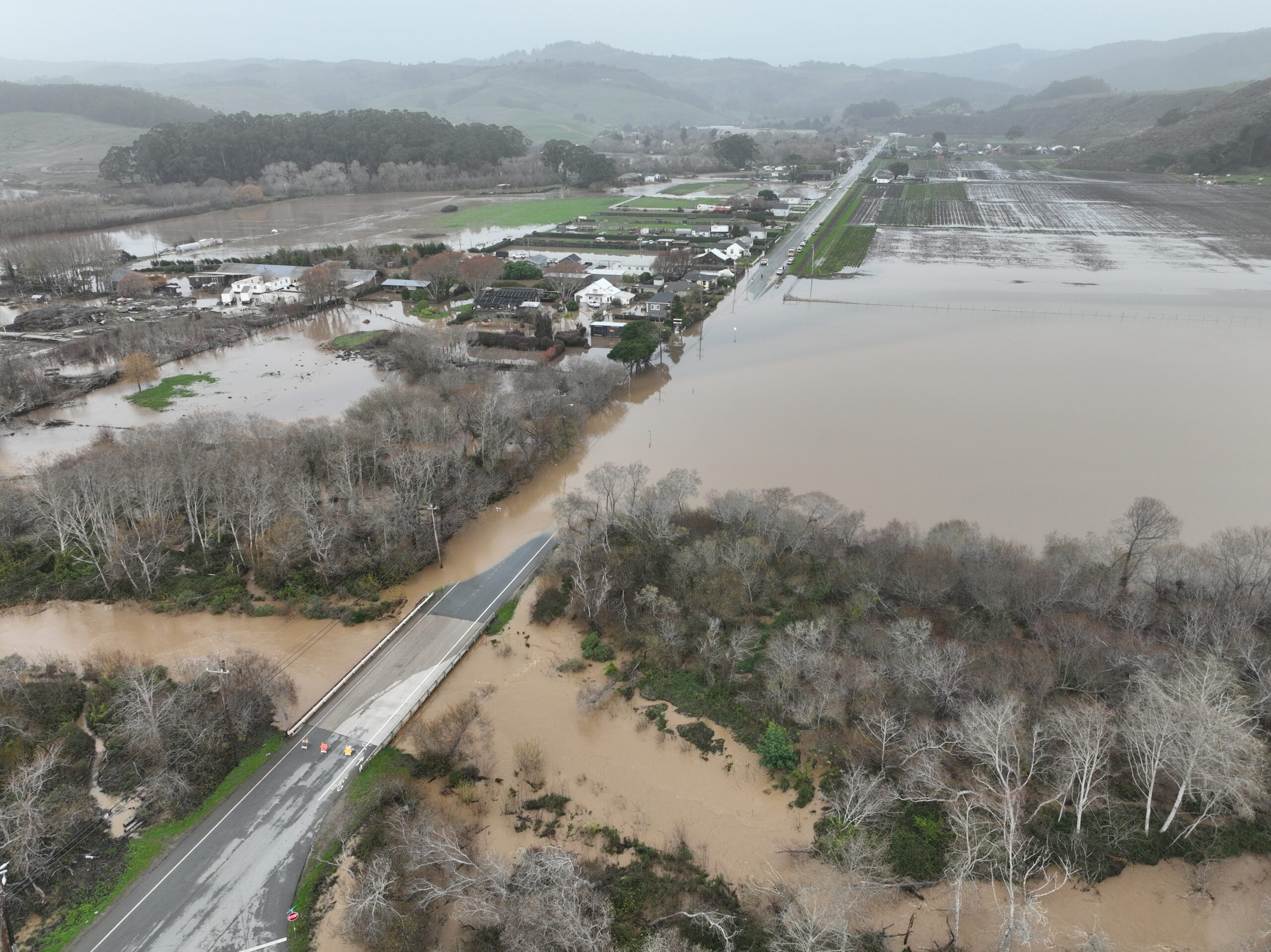 Flooding Aerial view of a flooded stretch of road, river, and farmland.